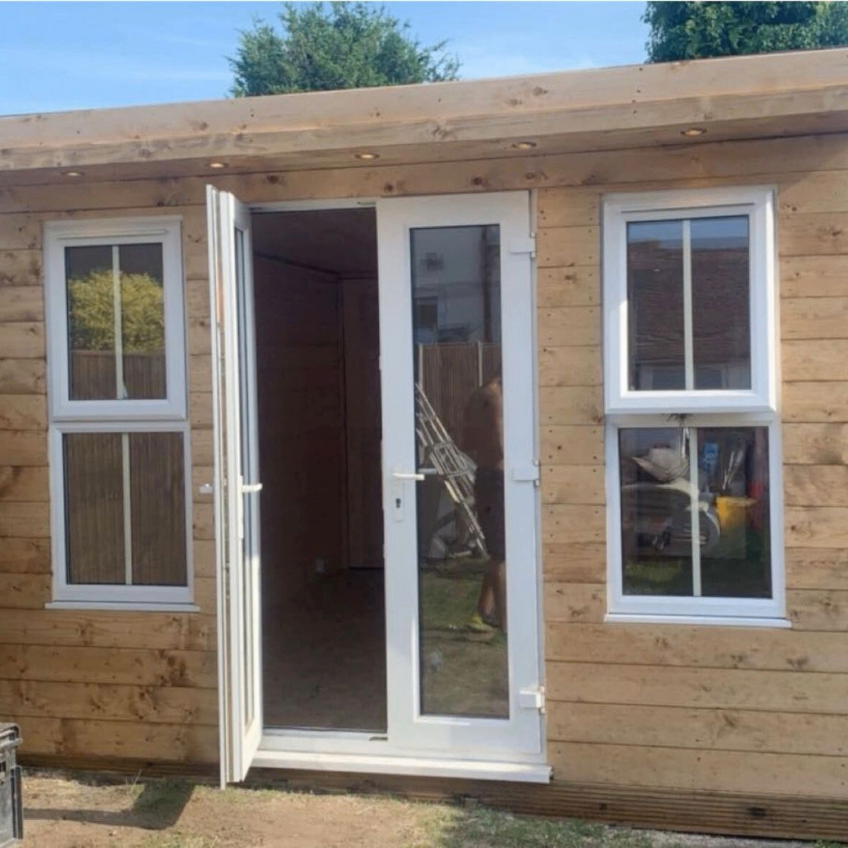 Compact timber garden office with white French doors
