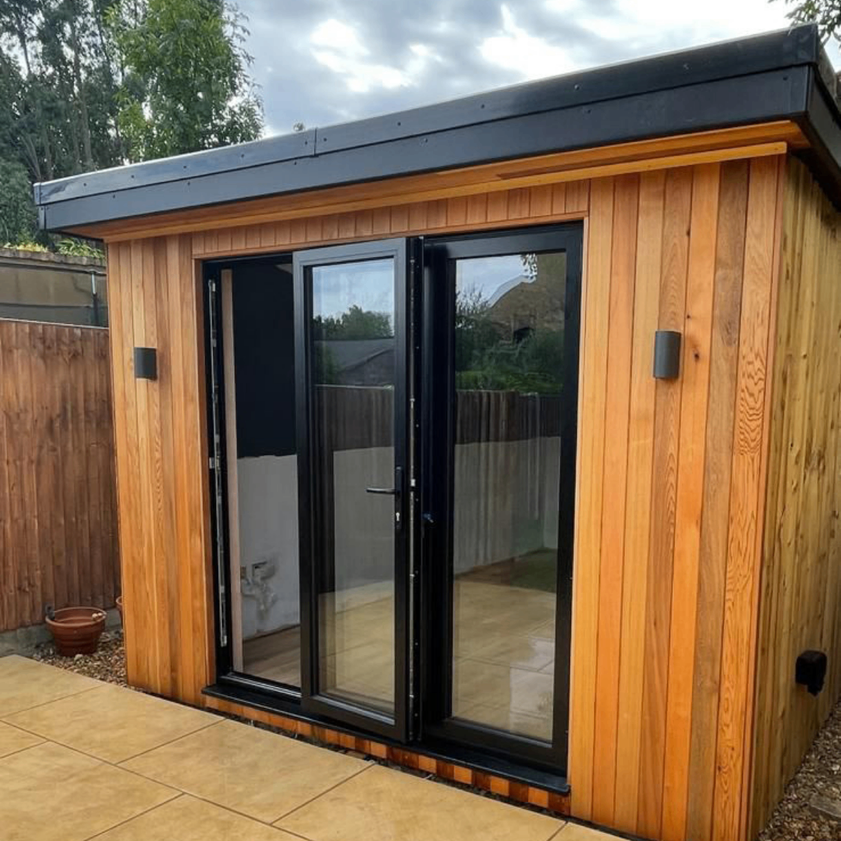 Cedar garden studio with vertical cladding and bifold doors